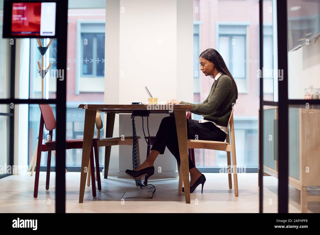 La empresaria trabaja en un portátil en una mesa en la sala de reuniones Foto de stock