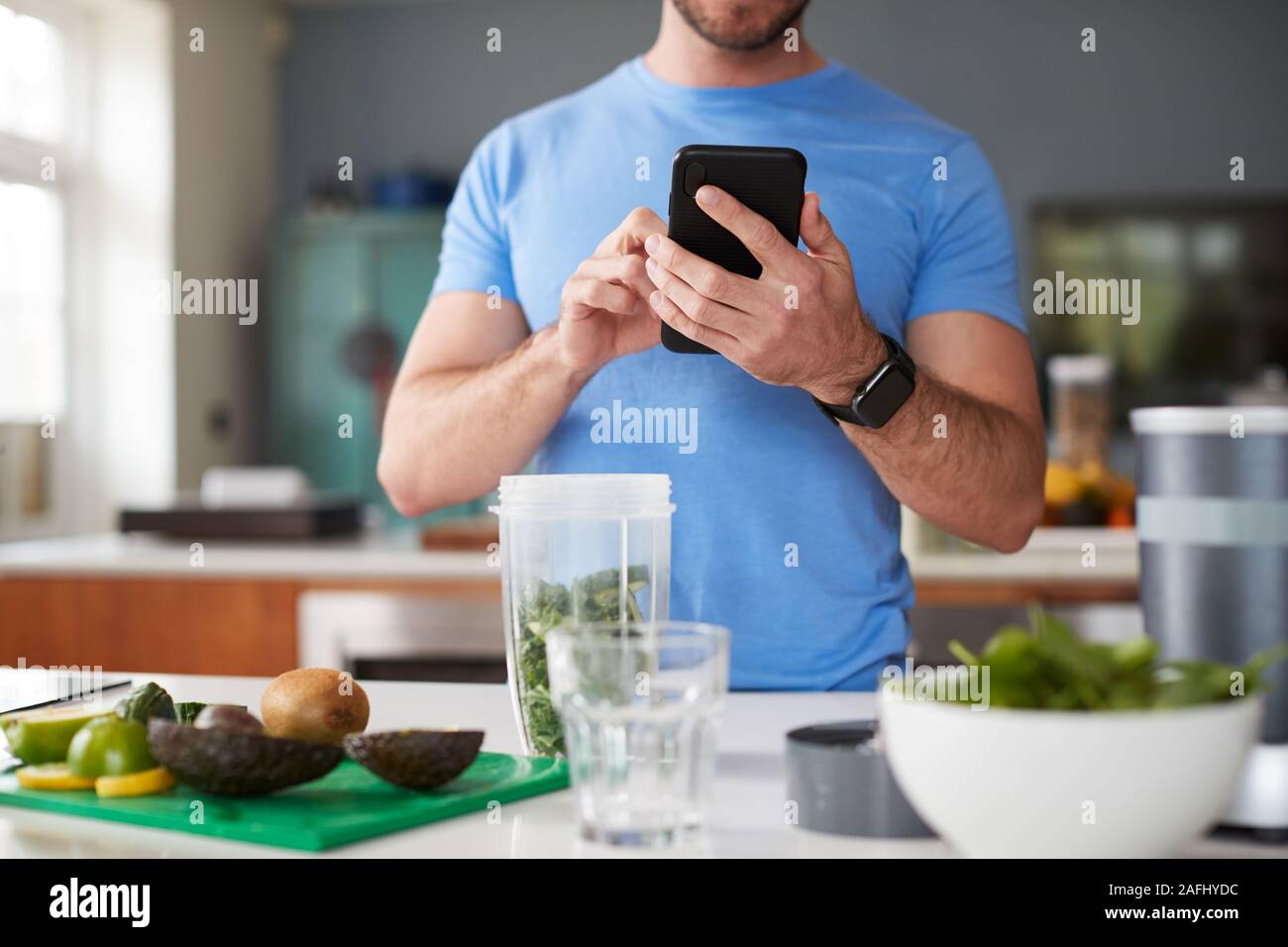 Cerca del hombre mediante el rastreador de fitness para contar calorías para Post entrenamiento jugos que está realizando Foto de stock