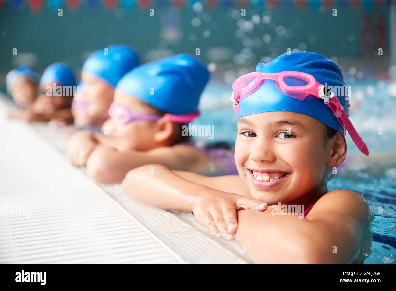 Retrato de niño en el agua en el borde de la piscina esperando la lección de natación Foto de stock