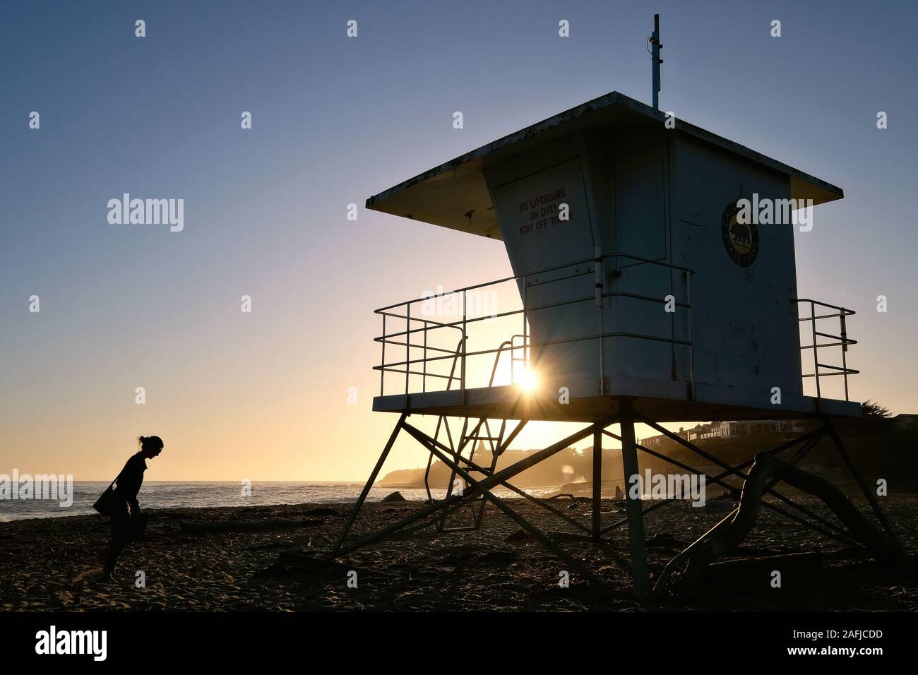 Atardecer en la Playa Estatal de puentes naturales con salvavidas torre, Santa Cruz, California, Estados Unidos. Foto de stock