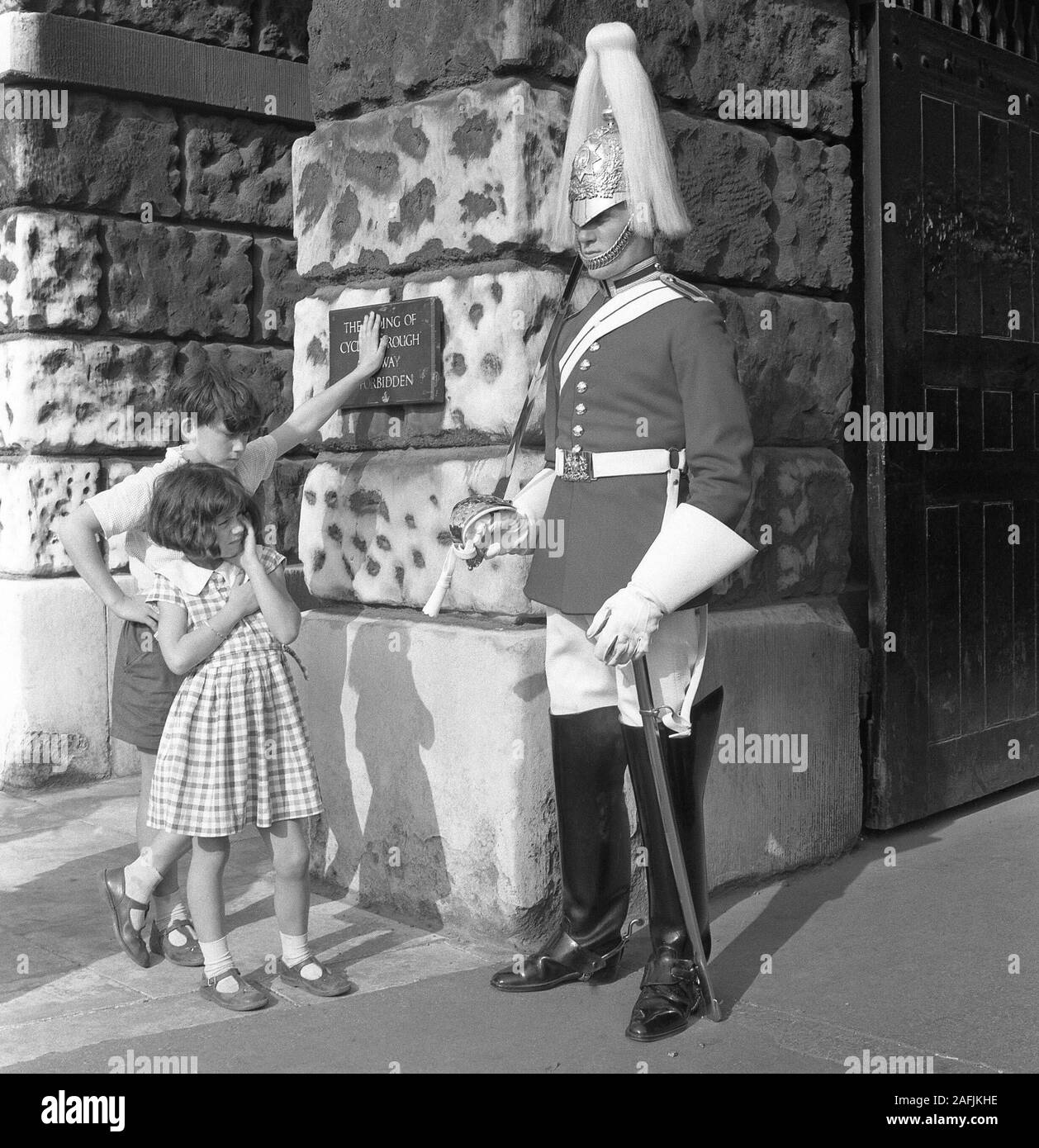 Los niños mirar un guardia británica en frente del Palacio de Whitehall en Londres. Foto de stock