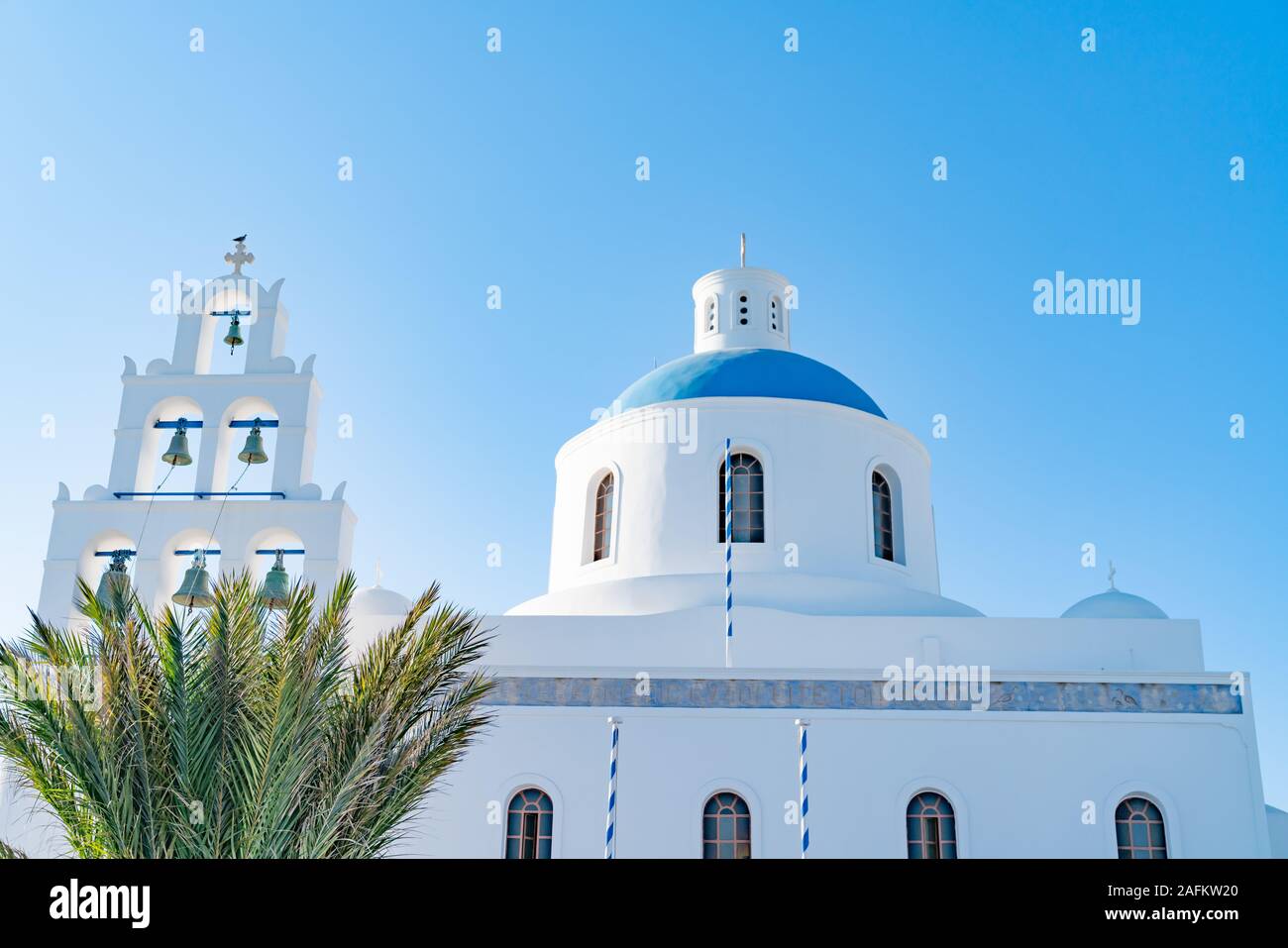 Oia, Grecia - El 7 de agosto de 2019; la iglesia de Panagia con seis campanario en Oia, Santorini en muros exteriores whitwashed cúpula azul brillante. Foto de stock