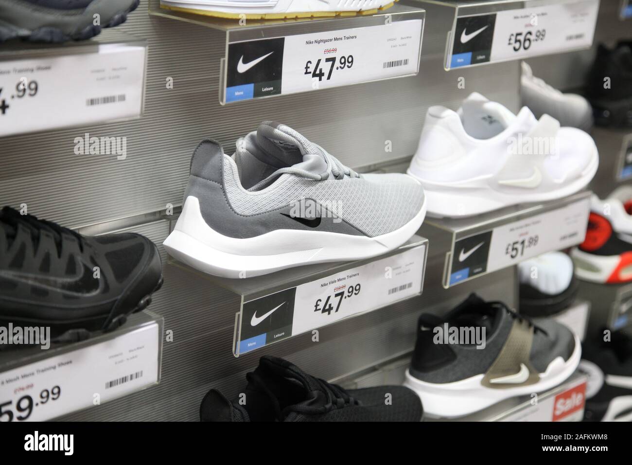 Una exposición de zapatillas de entrenamiento Nike con precios a la venta en tienda JD Sports, Epsom, Surrey, Fotografía de stock Alamy