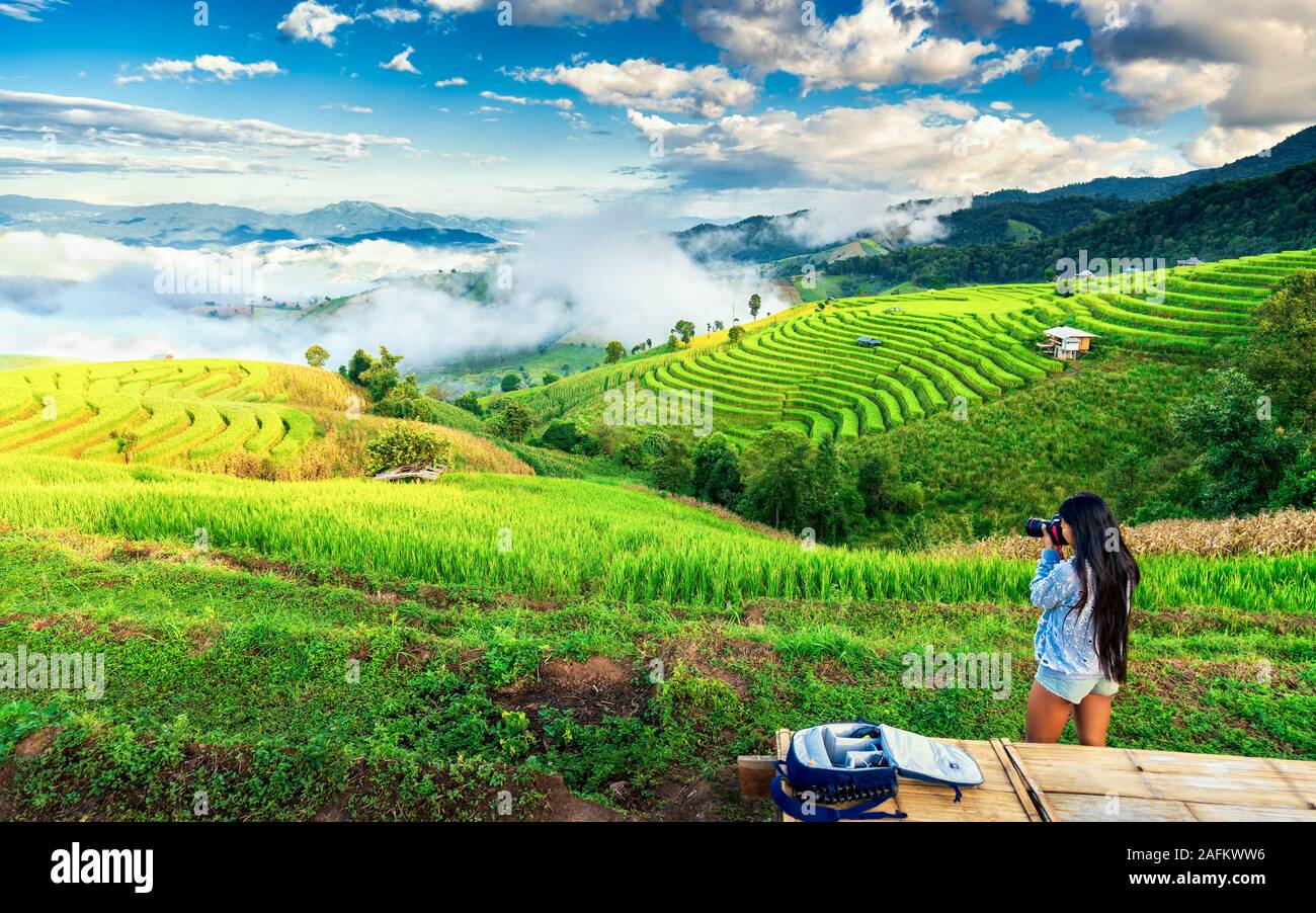 La chica del viajero hace foto paisaje natural y disfrutar del paisaje ver la terraza de arroz en Asia al amanecer. Estilo de vida activo y concepto de viaje Foto de stock