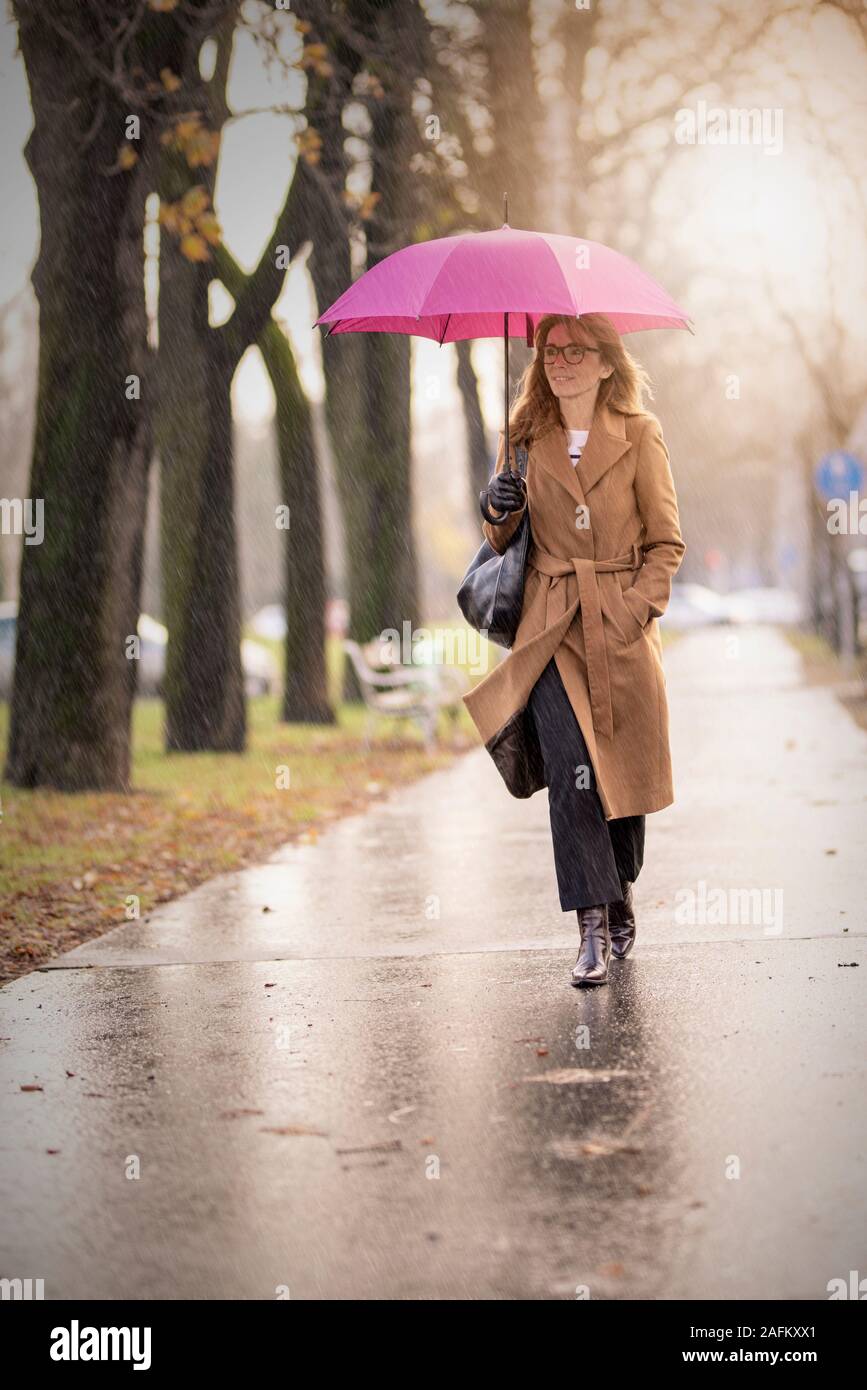 Mujer sosteniendo paraguas fotografías e imágenes de alta