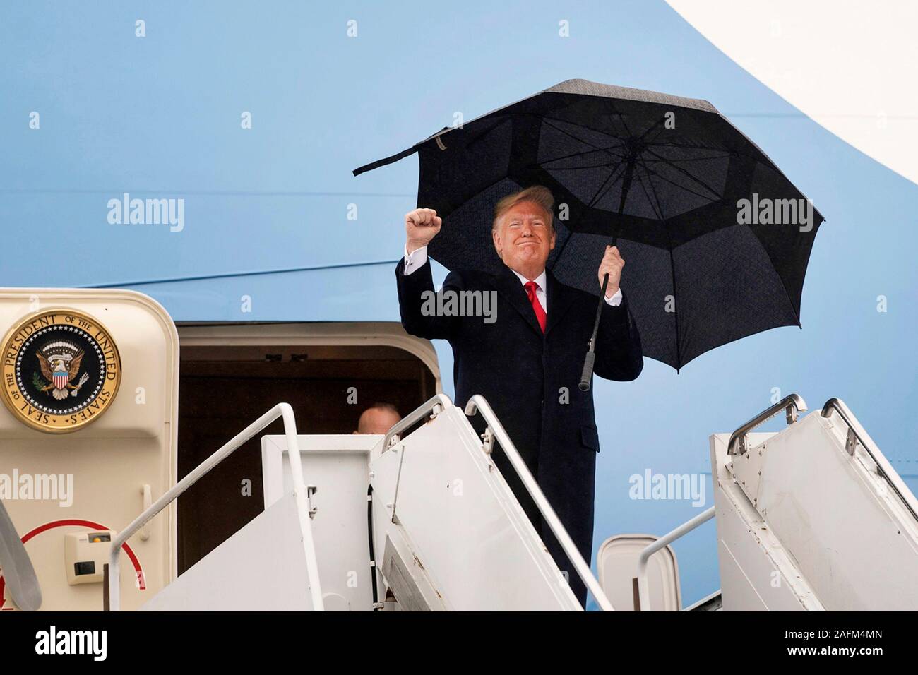El Presidente de Estados Unidos, Donald bombas su puño como él desembarca en Air Force One a su llegada al Aeropuerto Internacional de Filadelfia para asistir a la 120ª Army-Navy partido de fútbol el 14 de diciembre de 2019 en Filadelfia, Pensilvania. Foto de stock