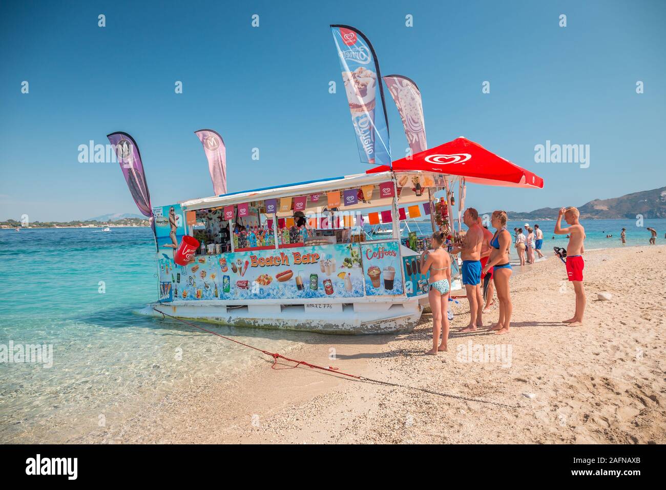 Zakynthos, Grecia, Isla Tortuga - Agosto 2019: tienda de barco flotante con frutas, helados y bocadillos diversos drinkg vendido desde pequeños botes, en Grecia Foto de stock