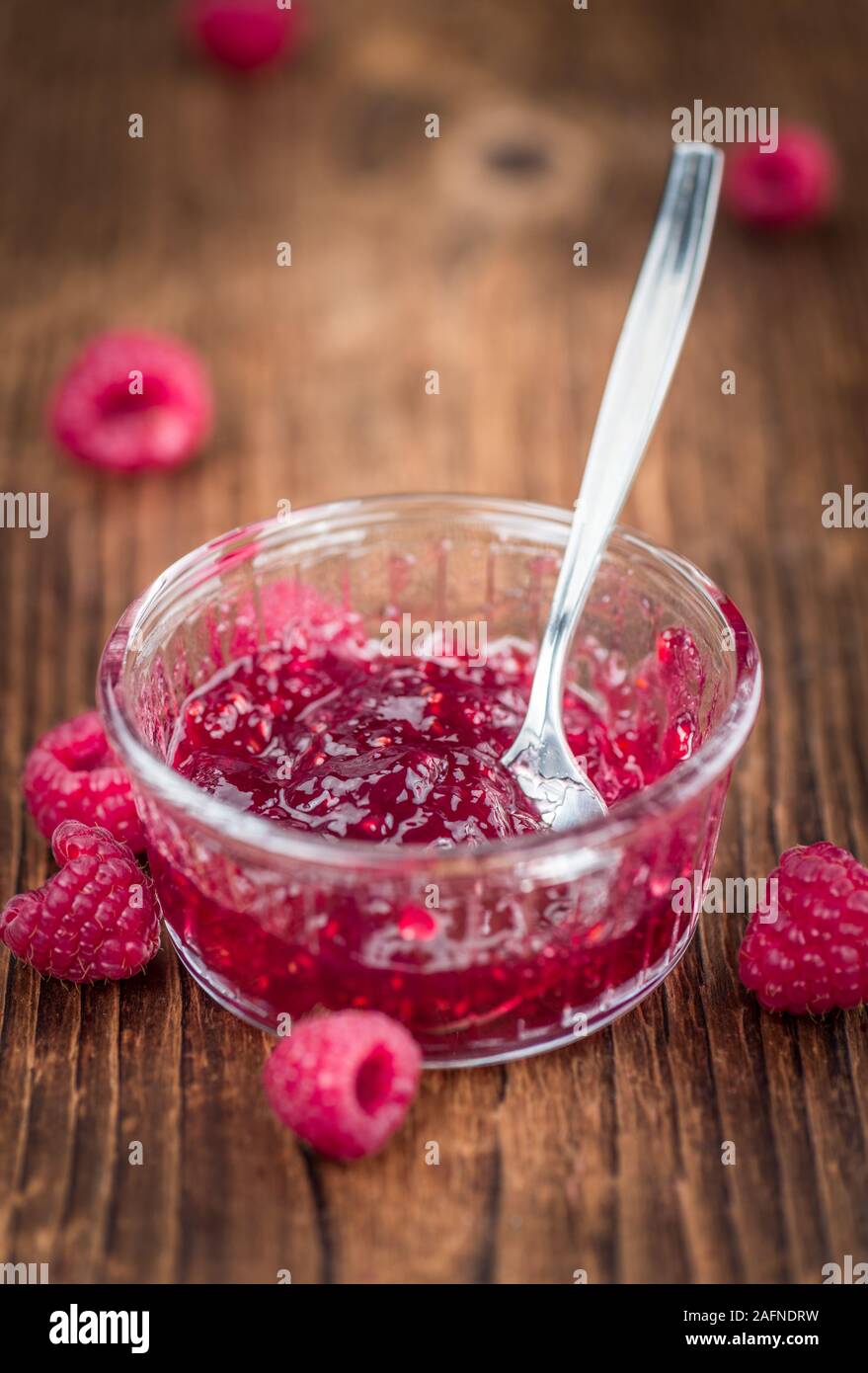 Raspberry Jam recién hechas en una antigua y rústica mesa de madera; el enfoque selectivo; primerísimos Foto de stock