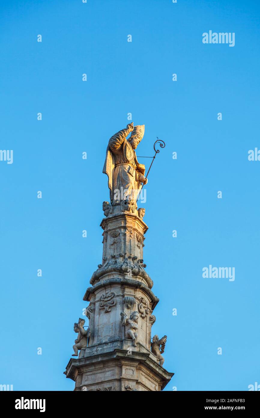 Estatua de San Oronzo (Saint Orontius) en una columna en Ostuni Plaza en el casco antiguo de Ostuni, en luz del atardecer Foto de stock
