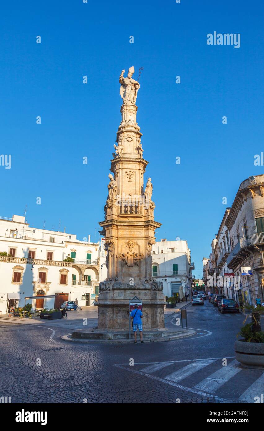 Estatua de San Oronzo (Saint Orontius) en una columna en Ostuni Plaza en el casco antiguo de Ostuni, en luz del atardecer Foto de stock