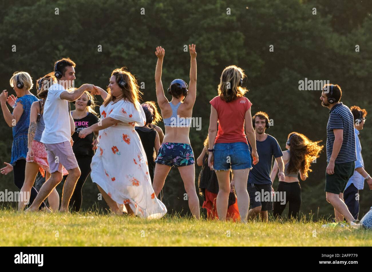 Los jóvenes bailan al aire libre durante una discoteca silenciosa Foto de stock