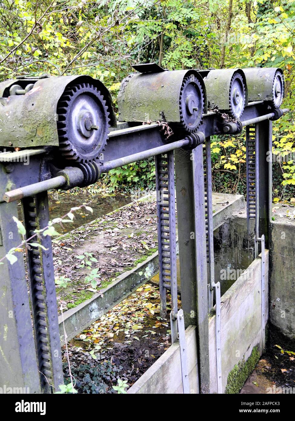 Viejos engranajes metálicos de una compuerta de esclusa Foto de stock