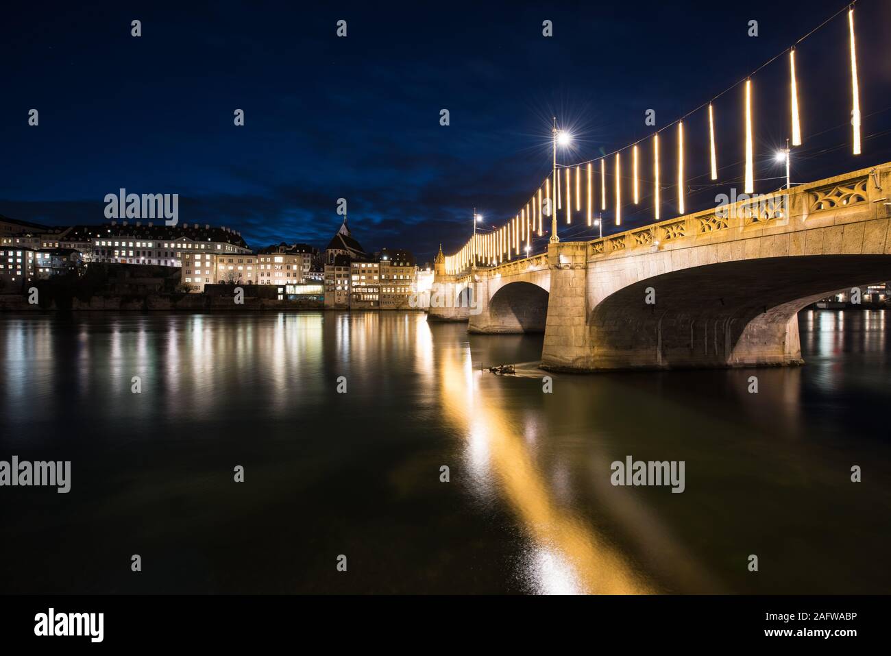 Basilea, Suiza en el río Rin con el medio puente en la noche. Foto de stock