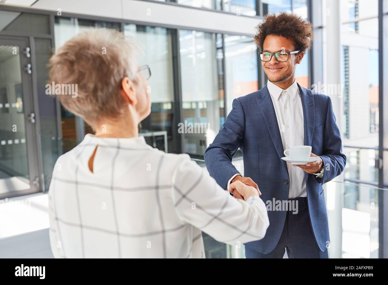 Africano joven hombre de negocios business partner saluda con handshake Foto de stock