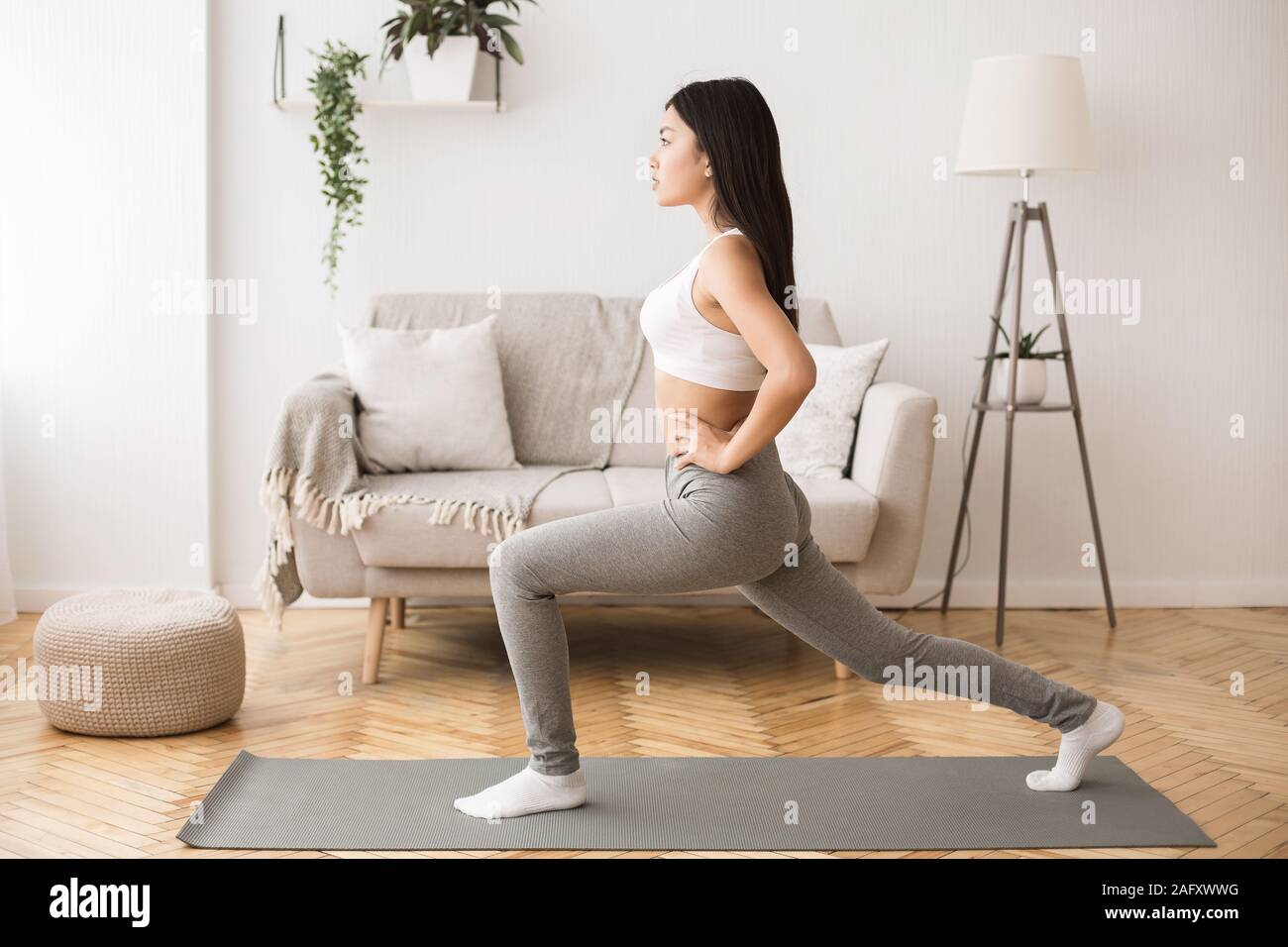 Chica haciendo gimnasia aeróbica flexibilidad de calentamiento, estiramiento de pierna Foto de stock