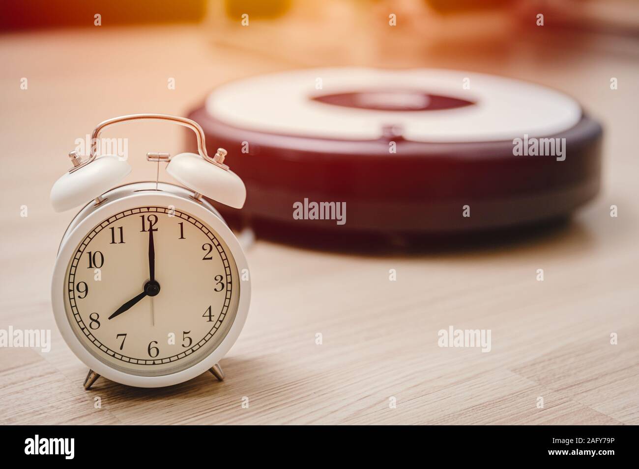 Reloj alarma veces para limpiar su hogar con aspiradora robot automático concepto. Foto de stock