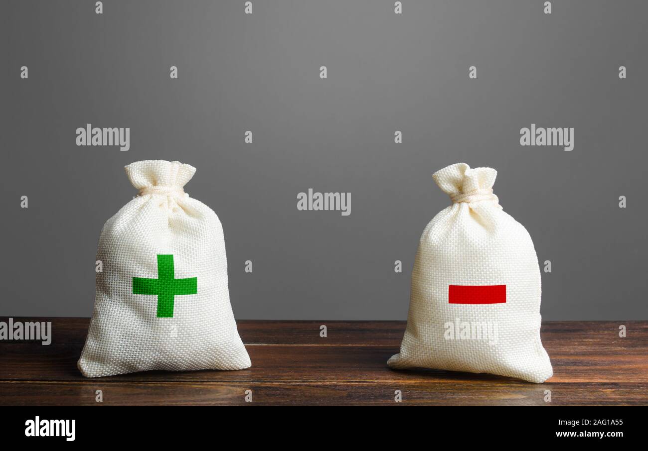 Dos bolsas con green plus rojo menos. Resumen y balance. Los ingresos y los gastos. Balanza comercial la presupuestación. Gestión financiera, beneficios, pérdidas. Ris Foto de stock