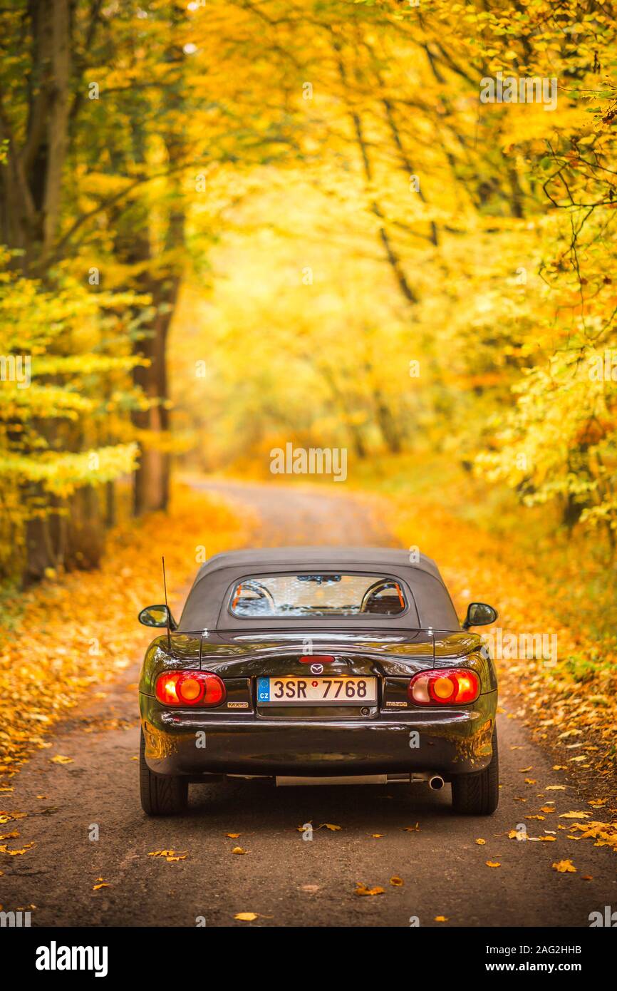 Praga, República Checa, Octubre 2019: Mazda MX-5 Miata NB de segunda generación, el modelo del año 1999 en un frondoso camino en otoño con bello otoño colorido Foto de stock