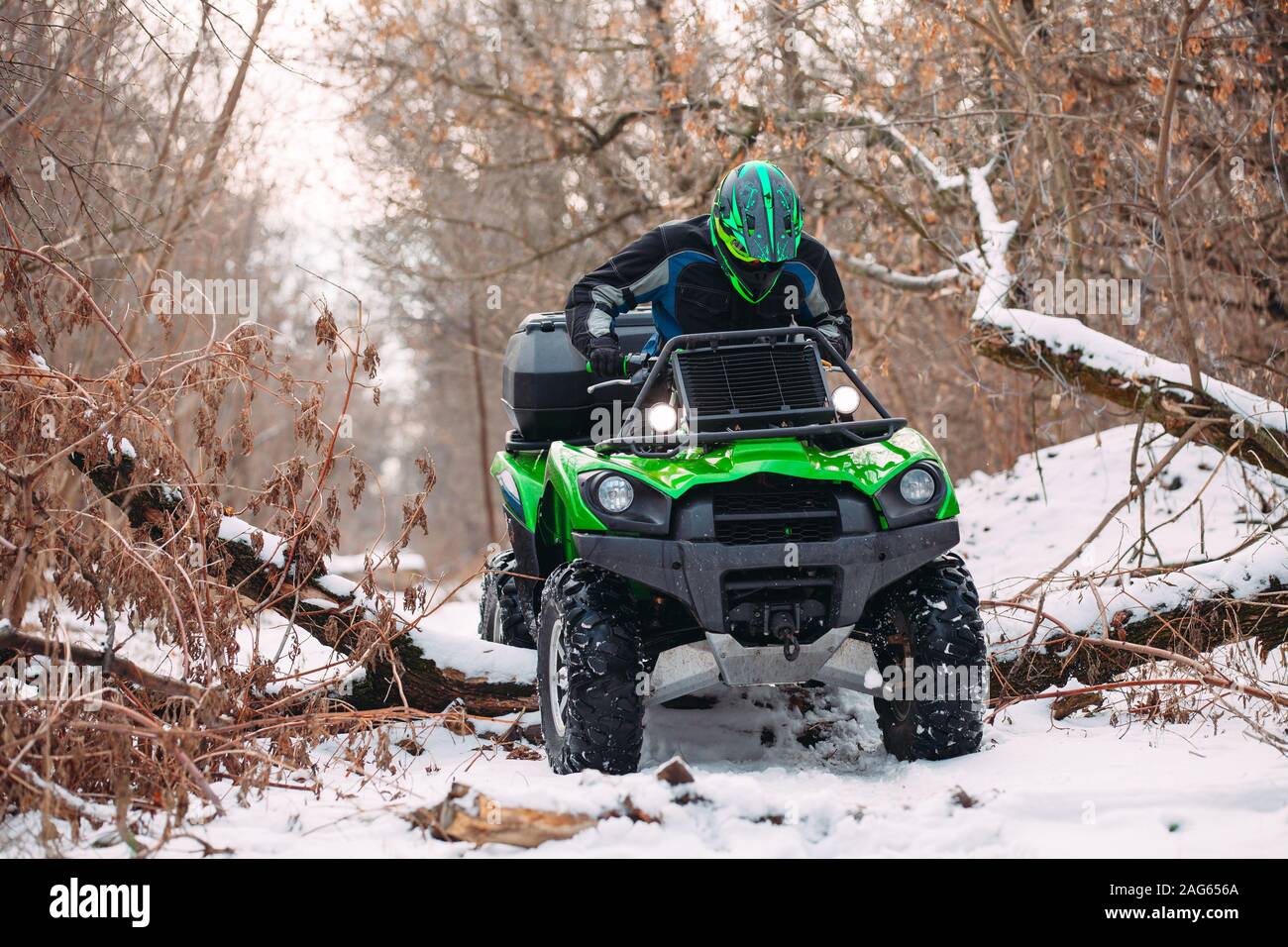 Rider conduce en la quadbike carrera en invierno en el bosque Foto de stock