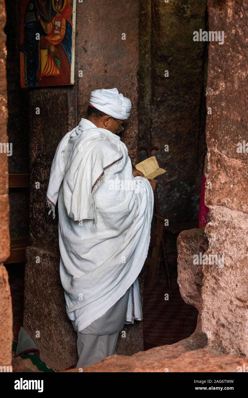 Etiopía, la región de Amhara, Lalibela, Bet Maryam, el devoto de la Iglesia Evangélica de lectura en el porche Foto de stock