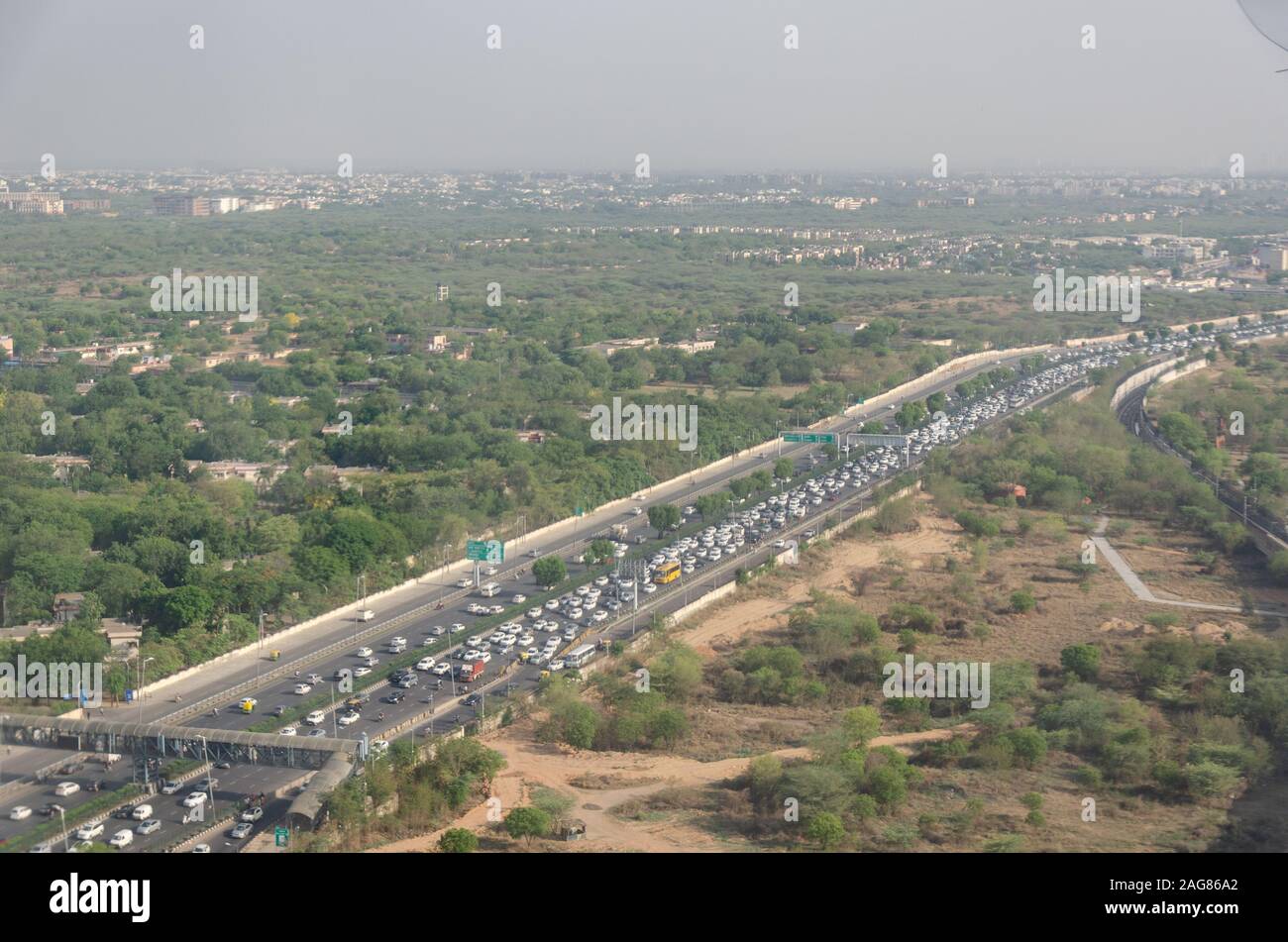 Vista de la congestión del tráfico de Delhi desde la ventana de vuelo a través de bruma contaminada en el aire. Foto de stock