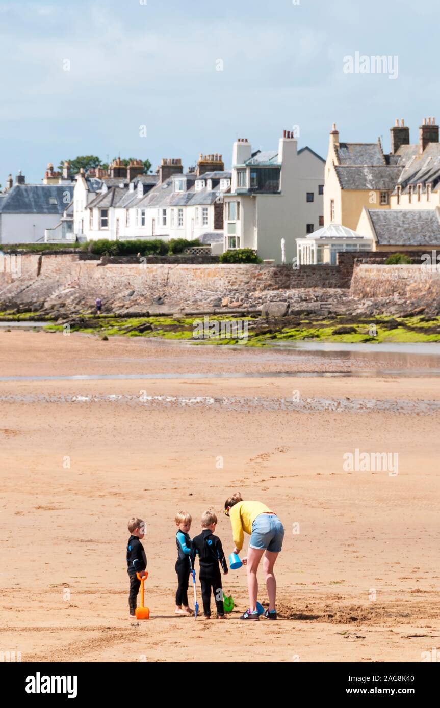 Mujer con niños en la playa a Elie, Fife. Foto de stock