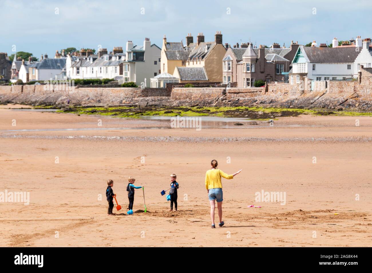 Mujer con niños en la playa a Elie, Fife. Foto de stock