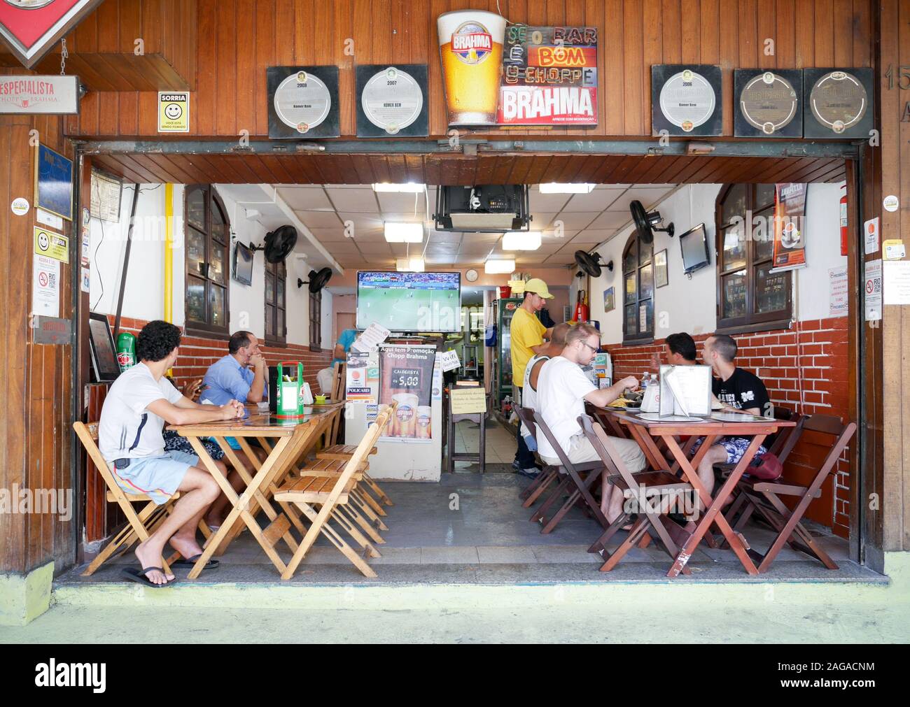 Los fanáticos del fútbol brasileño comiendo su almuerzo en típico restaurante café Río ve un partido de fútbol en la televisión Fotografía de stock - Alamy