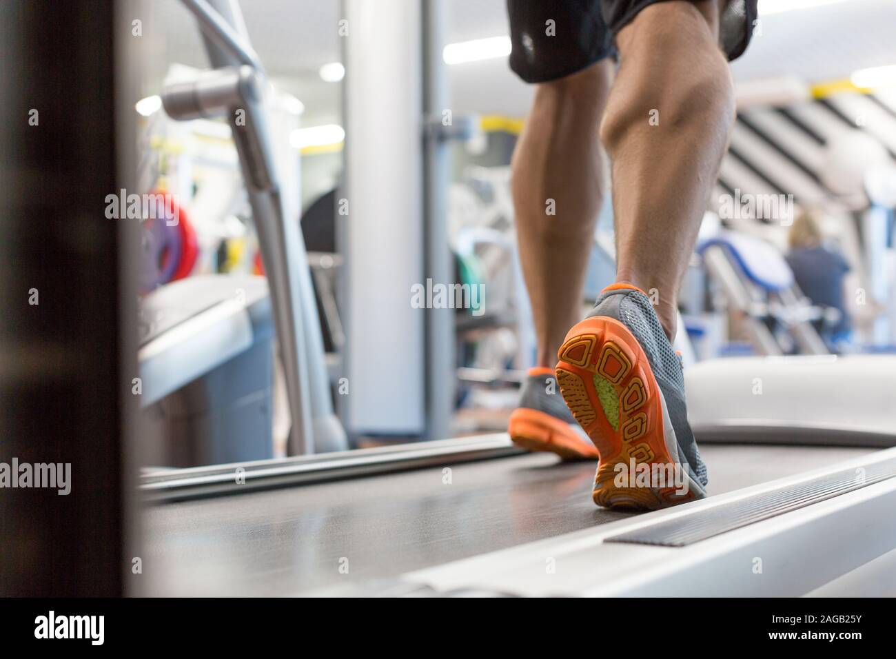 Cierre muscular masculina pies en zapatillas corriendo en la caminadora en el gimnasio. Fitness, Entrenamiento y concepto de estilo de vida saludable. Foto de stock