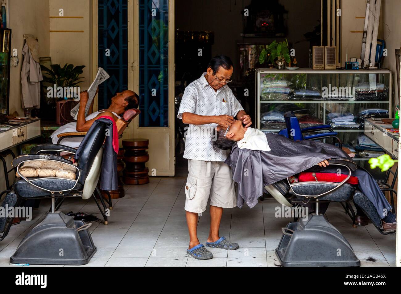Un hombre que tiene un afeitado húmedo en una barbería, Phnom Penh, Camboya. Foto de stock