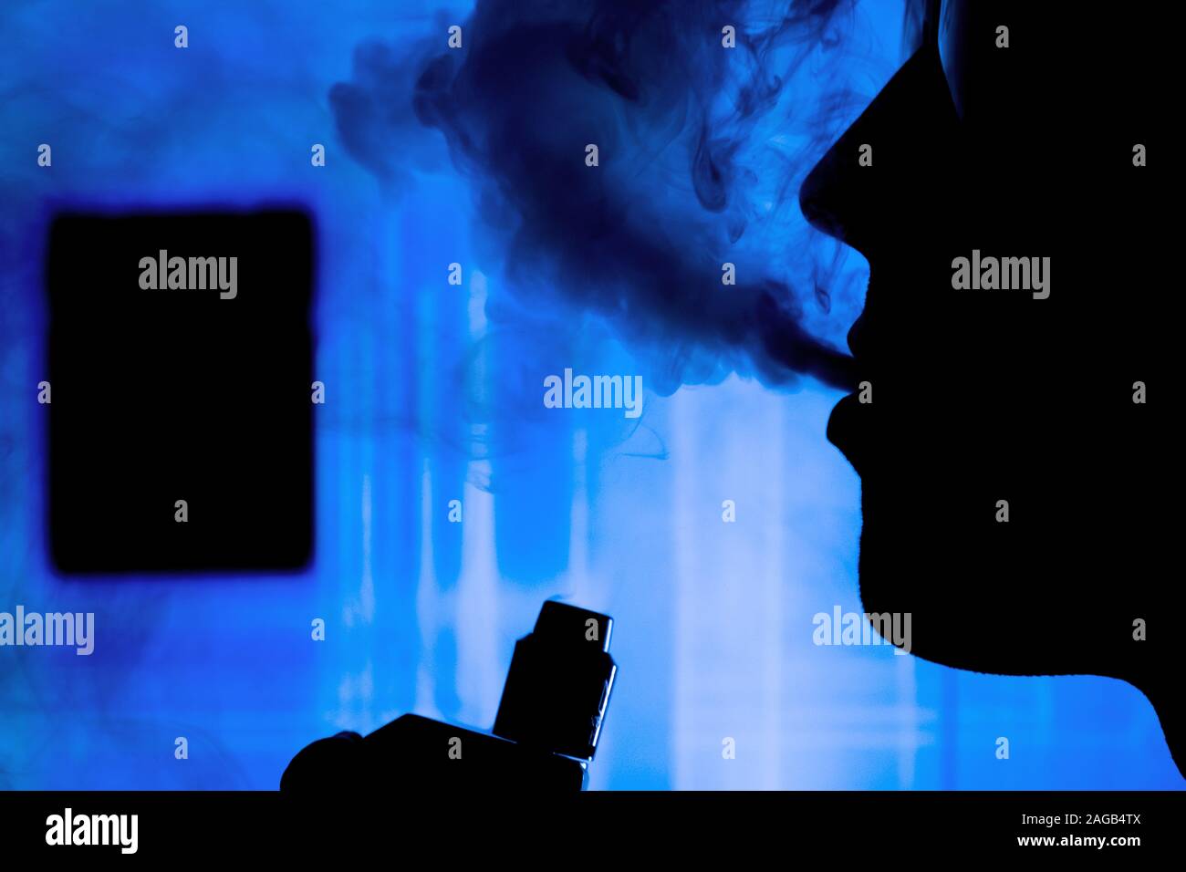 Hombre con humo de cigarrillo electrónico y con luces de neón vapping ayudar a dejar de fumar tabaco de fondo Foto de stock