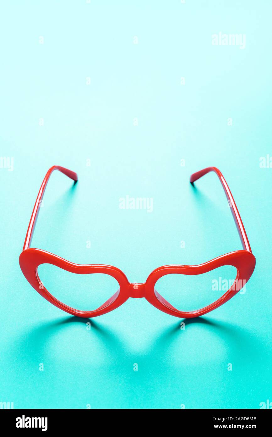 Las lentes de las gafas rojas en forma de corazón sobre un fondo azul  turquesa Fotografía de stock - Alamy