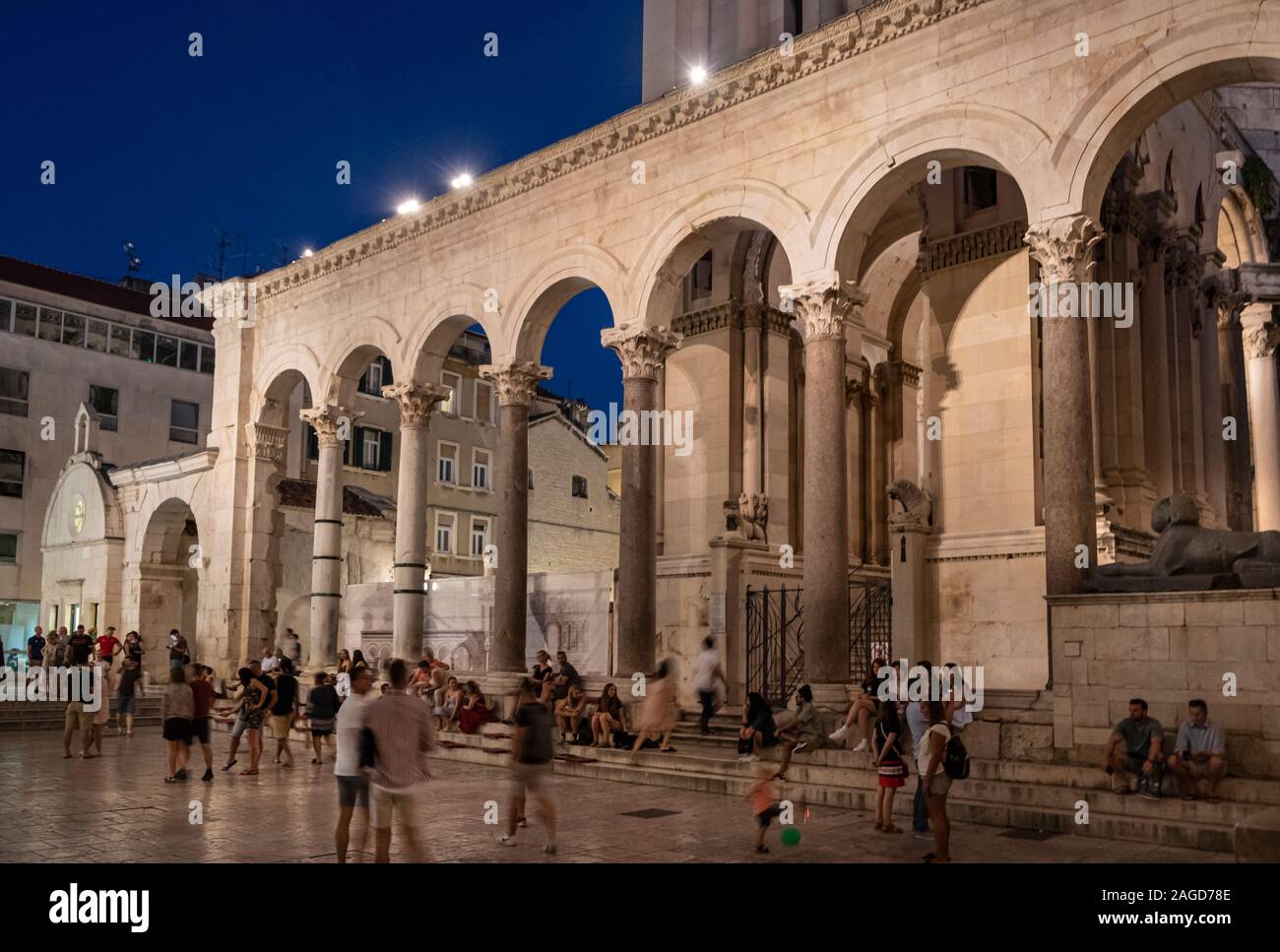 Las personas que beben y explorando la plaza dentro del Palacio de Diocleciano en la noche, Split, Croacia Foto de stock