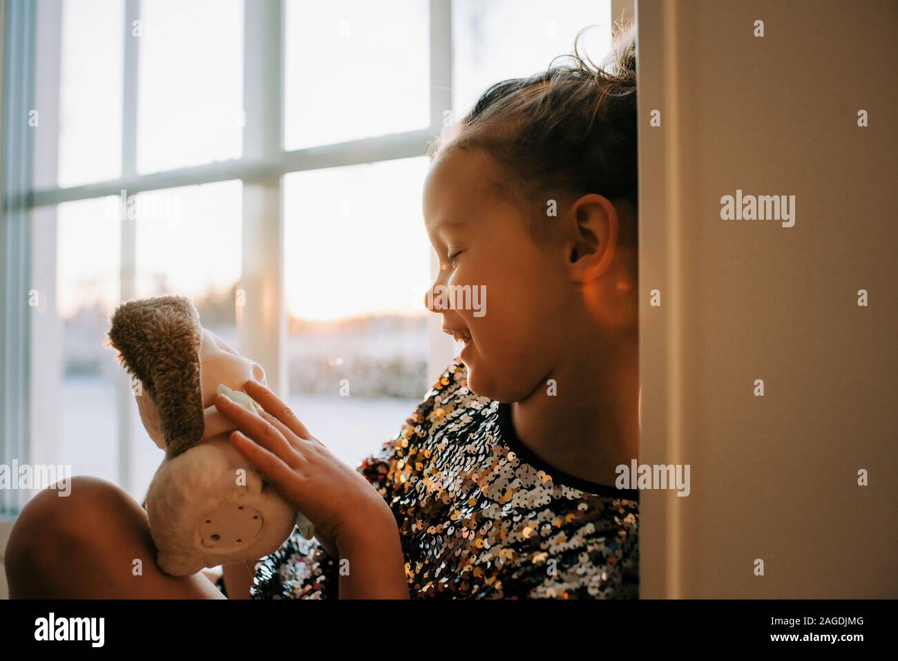 Niña jugando en casa con sus juguetes en Suecia al atardecer Foto de stock