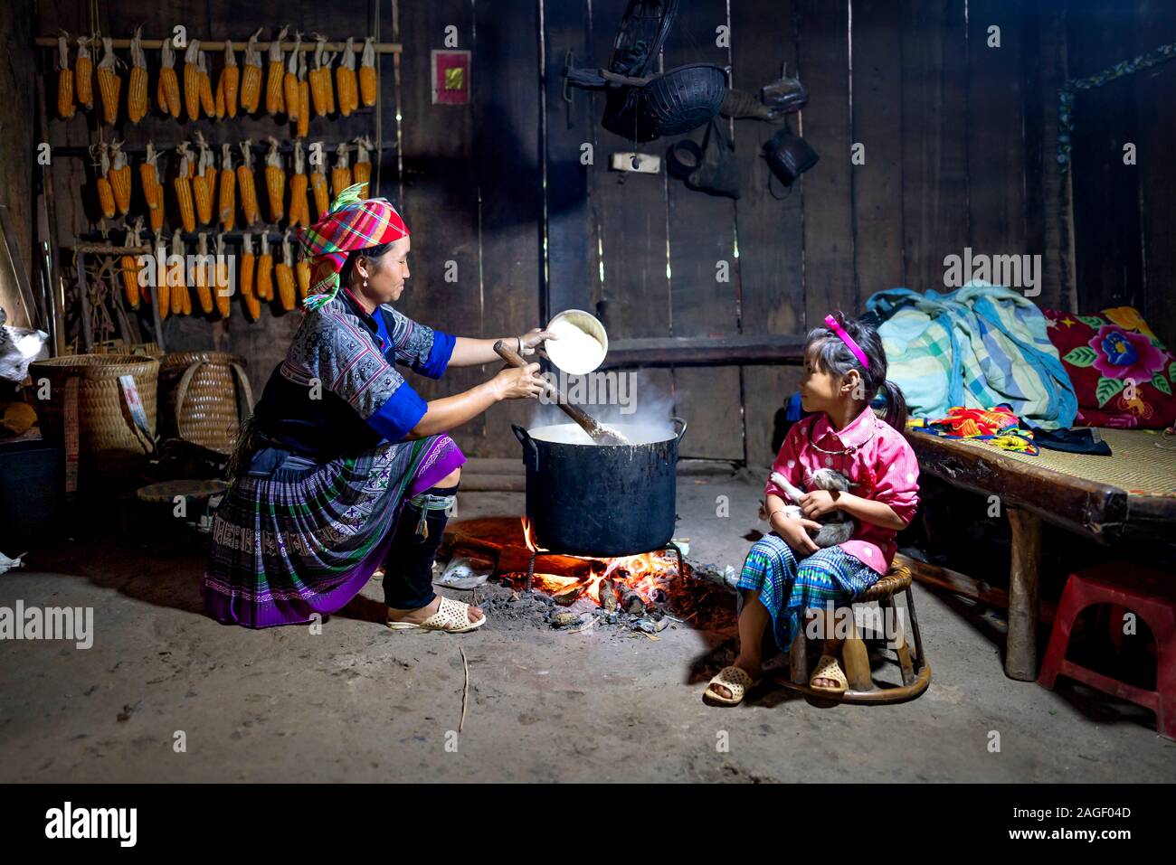 Mu Cang Chai, provincia de Yen Bai, Vietnam - Septiembre 20, 2019: La vida cotidiana escena de una minoría étnica H'Mong familia cocina con una estufa de leña en su Foto de stock