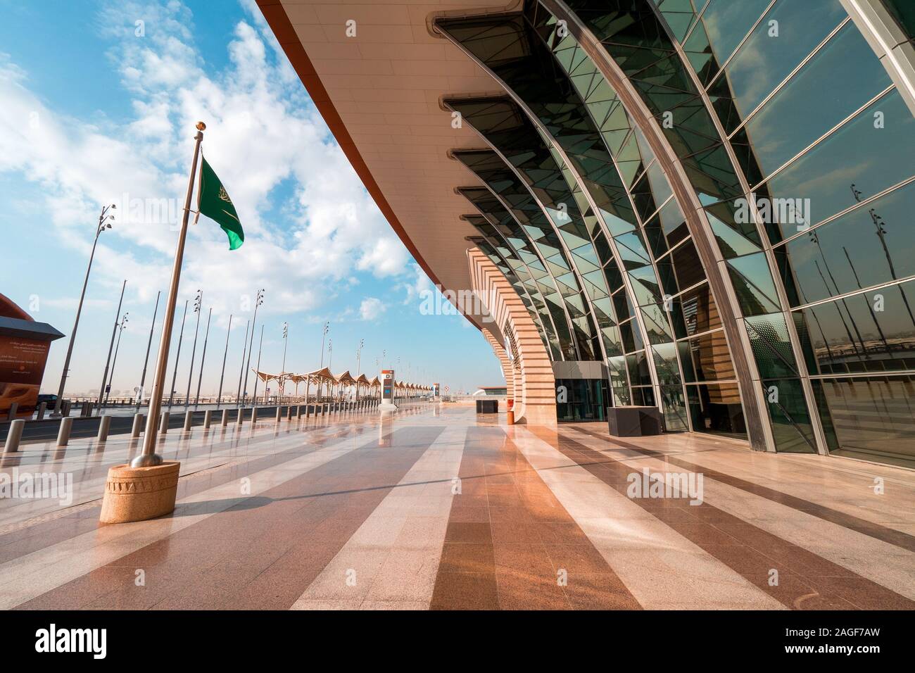 Arabia ondear la bandera en el viento, frente a la nueva Terminal 1 en el Aeropuerto Internacional Rey Abdulaziz (JED) en Jeddah, Arabia Saudita Foto de stock