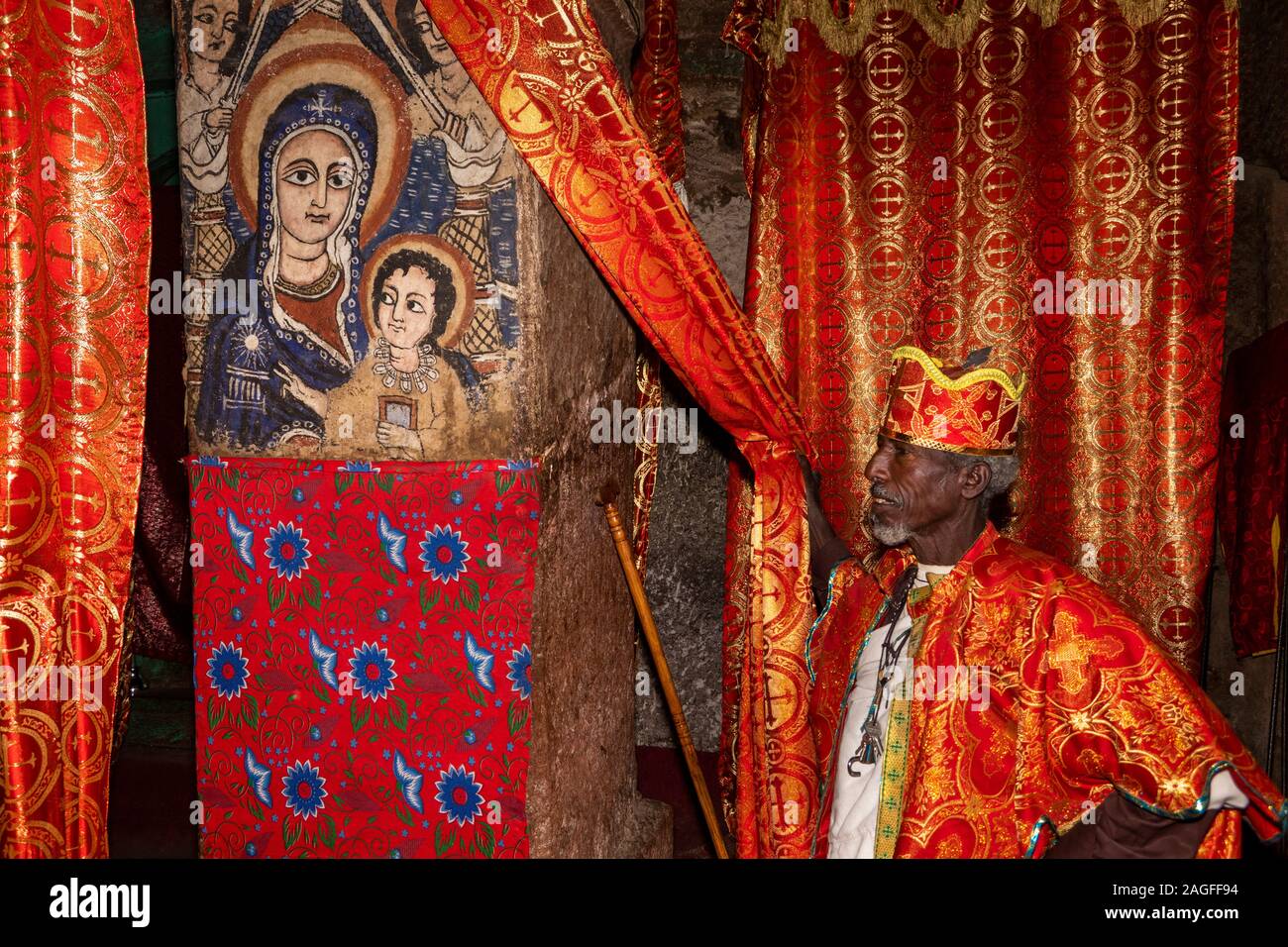 Etiopía, la región de Amhara, Lalibela, Arbatu Ensessa, Biblia Chirkos, sacerdote en batas de baño mostrando natividad pintura mural Foto de stock