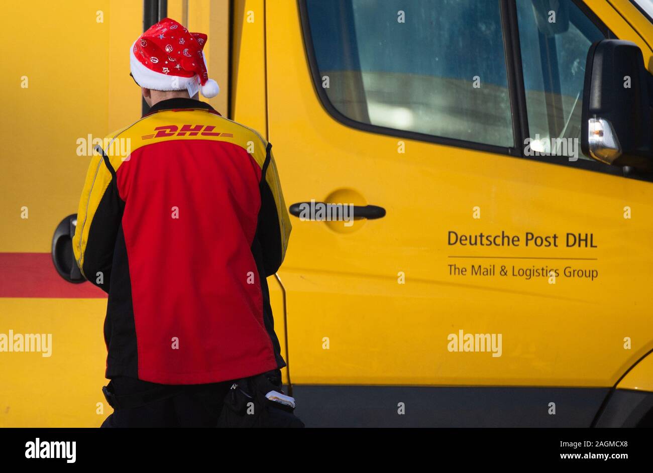 Wolfsburg, Alemania. 20 diciembre, 2019. Un liberador de paquetería DHL  Deutsche Post lleva una tapa de Santa Claus en el trabajo. Alrededor de  25.000 generadores adicionales se utilizarán para la temporada navideña