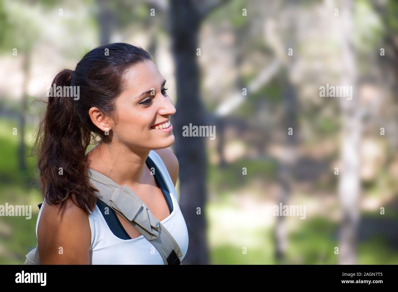 Mujer sonriente retrato vista lateral. Los jóvenes caucásicos chica española contra campos de agricultura. La libertad en la naturaleza. Foto de stock