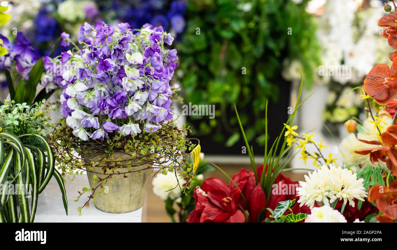 Flores artificiales para la decoración interior. Hermosa flor de arveja  melodiosa azul en un bote. Decoración horizontal diseño floral. Tejido  brillante amago flor co Fotografía de stock - Alamy