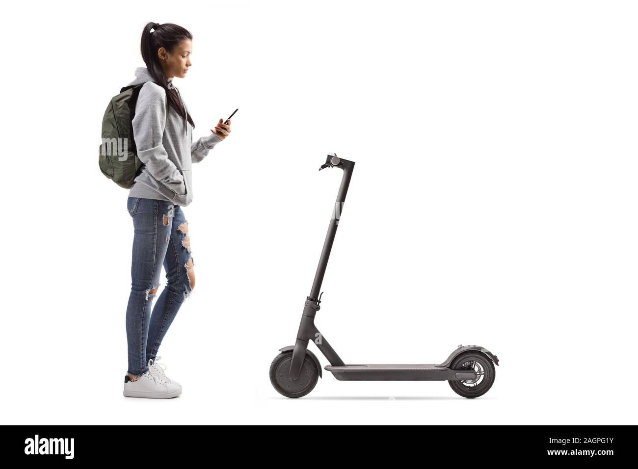 Perfil de longitud completa la foto de un estudiante alquilar un scooter eléctrico con un teléfono móvil aislado sobre fondo blanco. Foto de stock