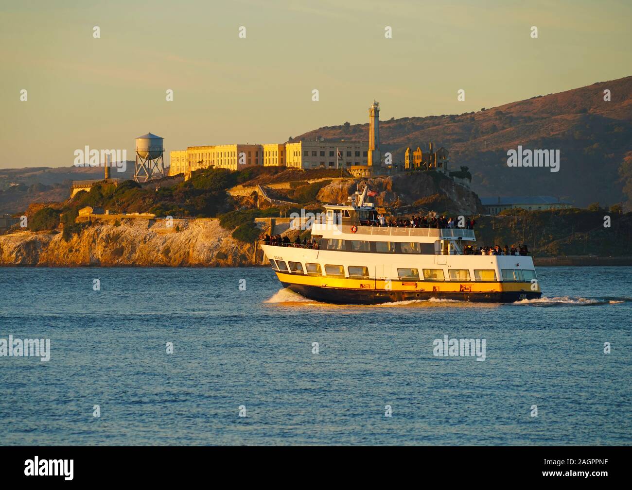 El ferry casco azul del Blue & Gold Fleet pasando la Isla de Alcatraz, en la Bahía de San Francisco en el camino a Sausalito. Foto de stock