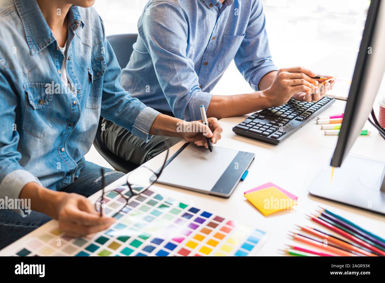 Gráfico creativo arquitecto profesional ocupación desiner escogiendo el color de la paleta pantone muestras para el proyecto de equipo de escritorio de la oficina. Foto de stock