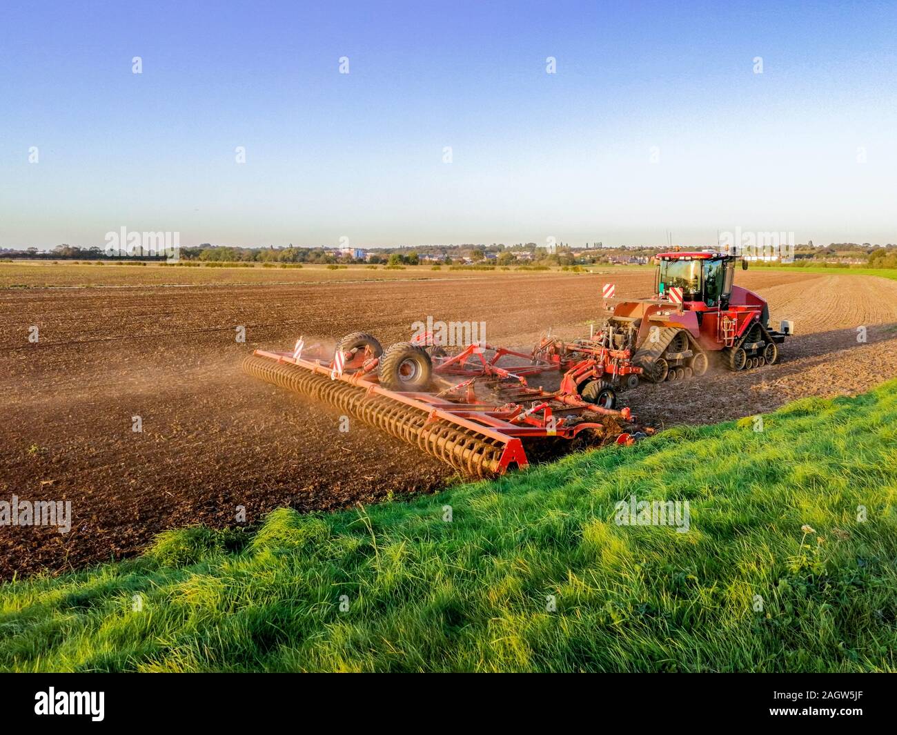 Una hermosa tarde de verano en la campiña británica de tierras planas, campos abiertos con pastos y araban la tierra como el sol se pone en el fondo. Foto de stock