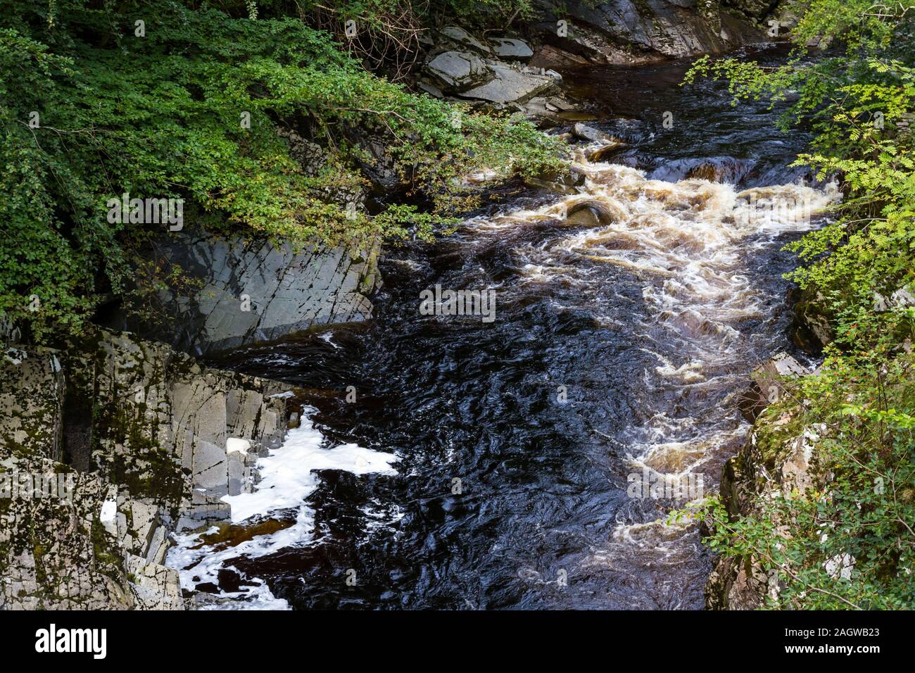 Marrones aguas corriendo en las Highlands escocesas como producto de la turba en el Altiplano Foto de stock
