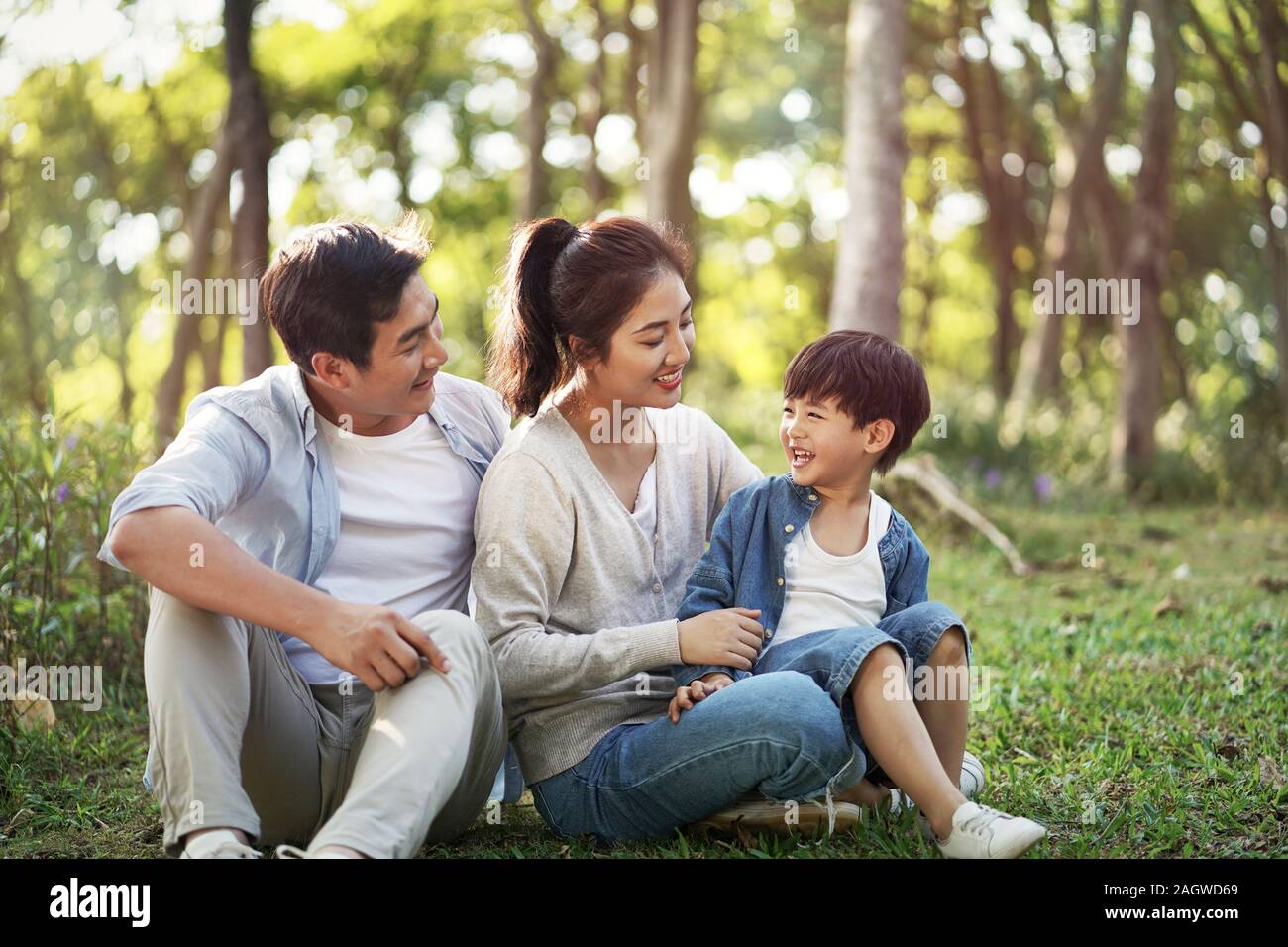 Los padres y el hijo joven asiático divertirse al aire libre en el parque Foto de stock