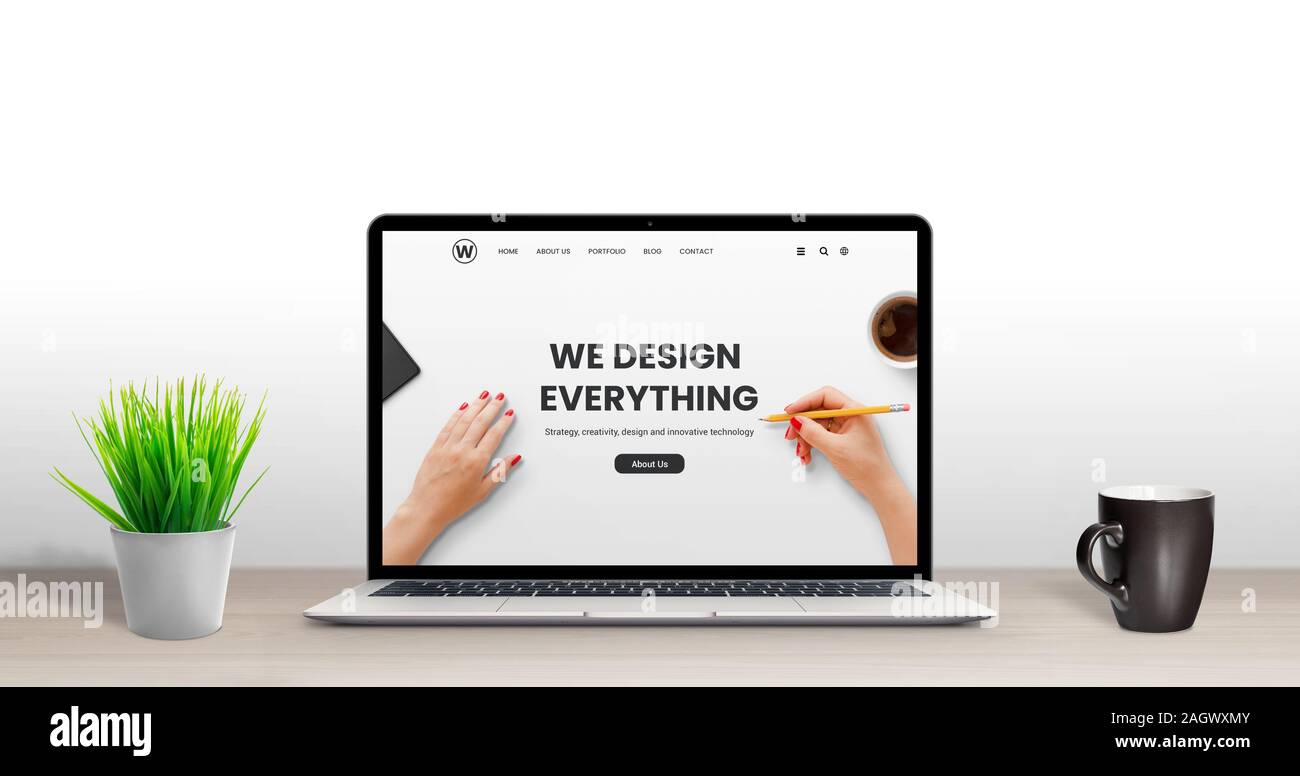 Web design studio concepto. Latop con moderno diseño plano, página web de la agencia en el escritorio. Planta y la taza de café al lado Foto de stock