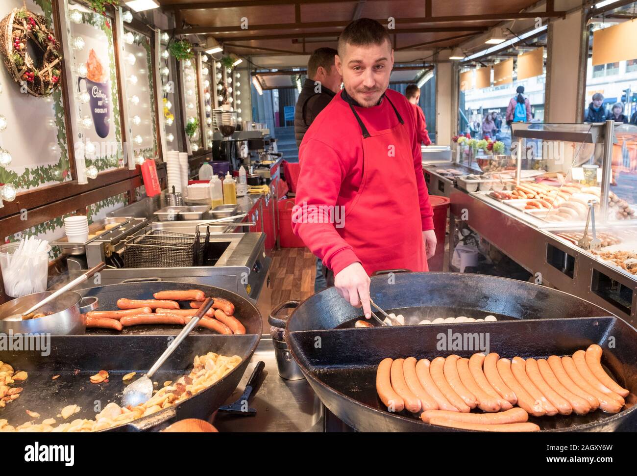 Chef de cocina de salchichas en el mercado de Navidad de Edimburgo. Foto de stock