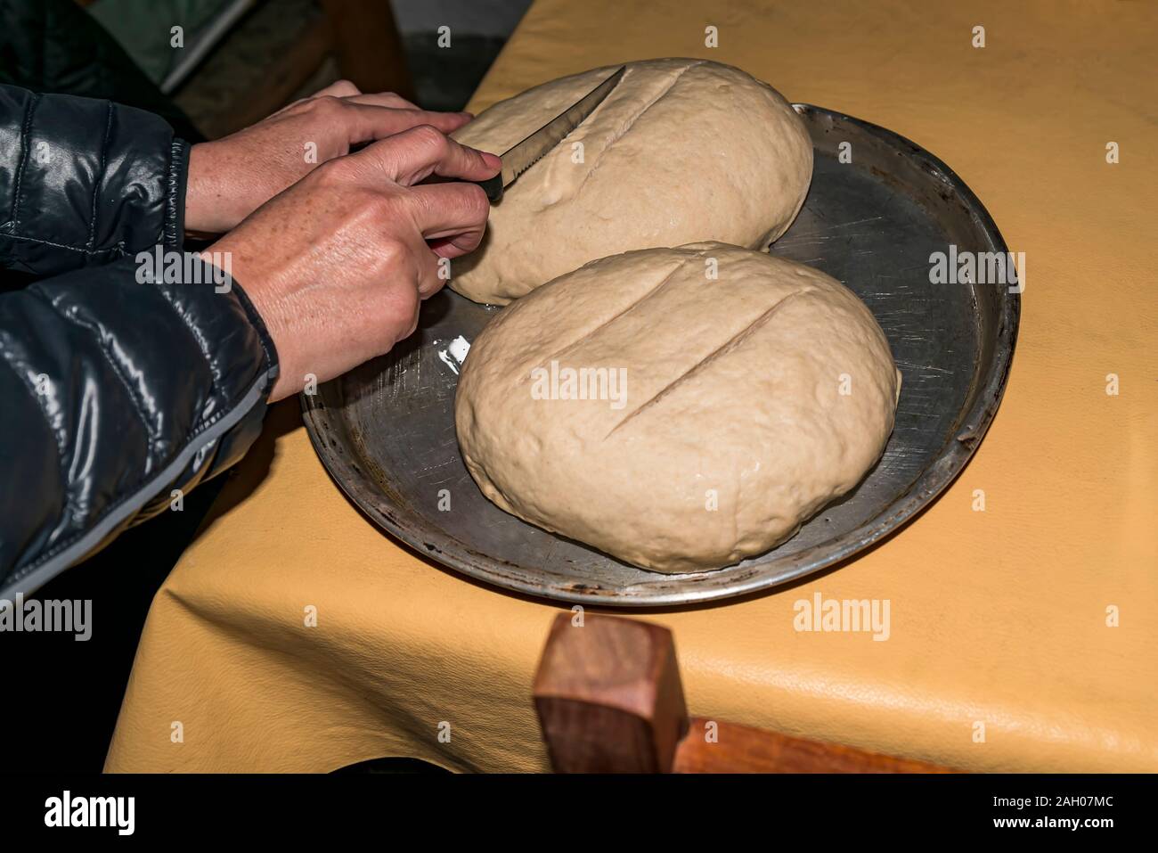 Pan redondo de artesanales caseros recién horneados pan de masa fermentada en placa de corte Foto de stock