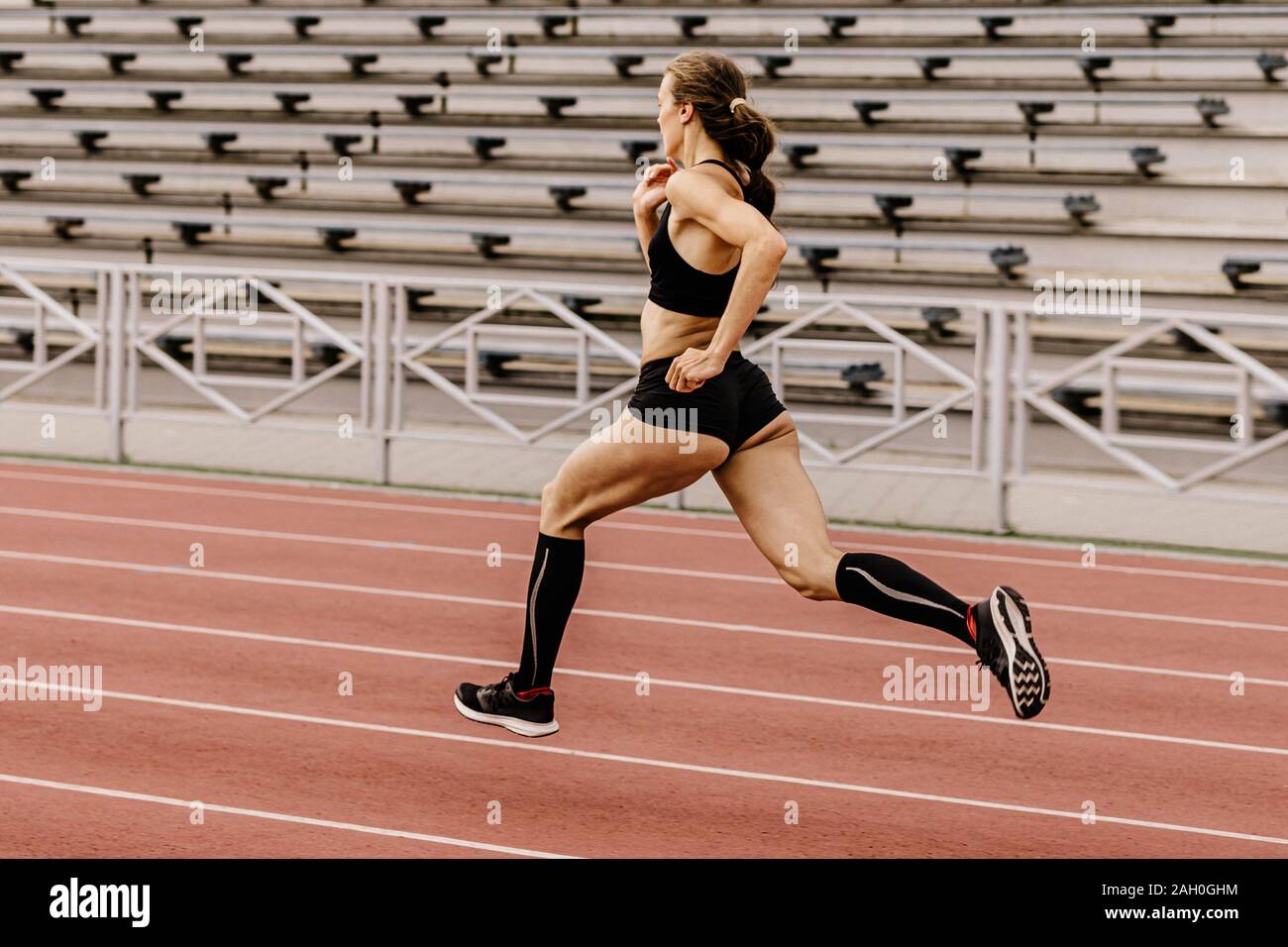 Atleta Femenina runner ejecute el estadio de asientos tipo estadio de fondo Foto de stock